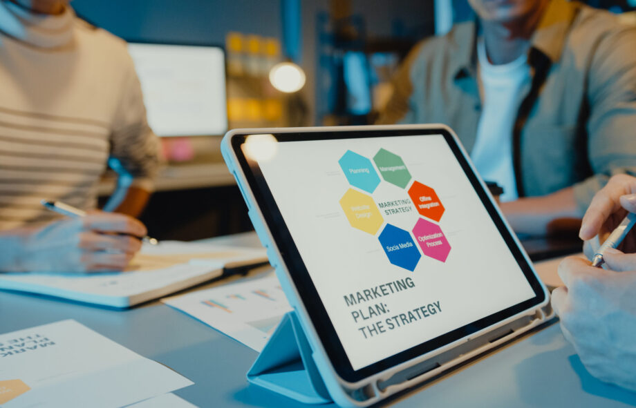 Asia businesspeople meeting plan analysis statistics brainstorm and header of team hold tablet point graph chart and employee take note in modern home office night. Finance strategy success concept.