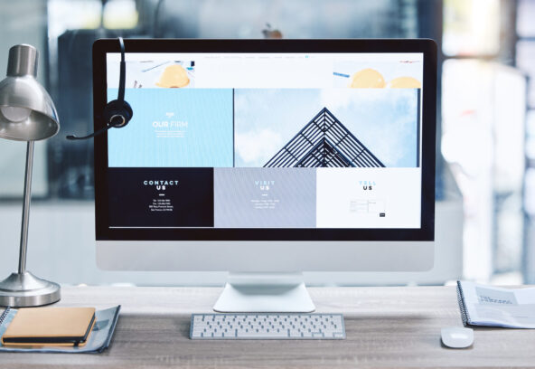 Webpage advert on computer desktop screen monitor in an empty call centre office. Operating helpdes.